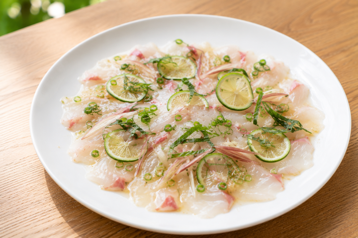 自然光の食卓に置いた白身魚のカルパッチョ